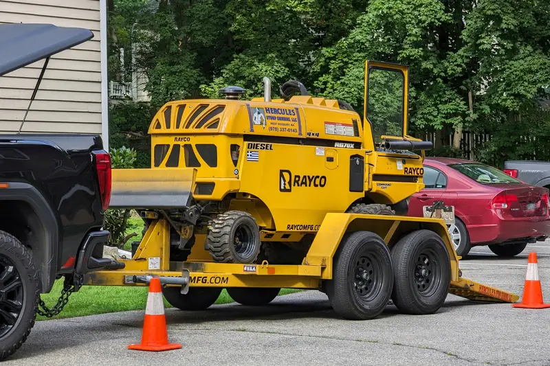 Tow-behind stump grinder parked on a trailer